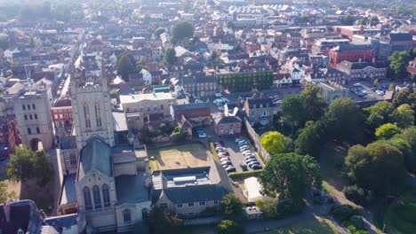 -St-Edmunds-bury-Cathedral-with-garden-complex-and-urban-city,-aerial-drone-tracking-shot