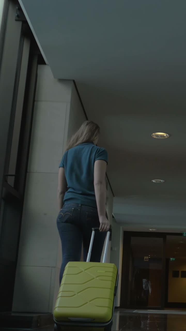 Woman traveling with luggage in an airport corridor