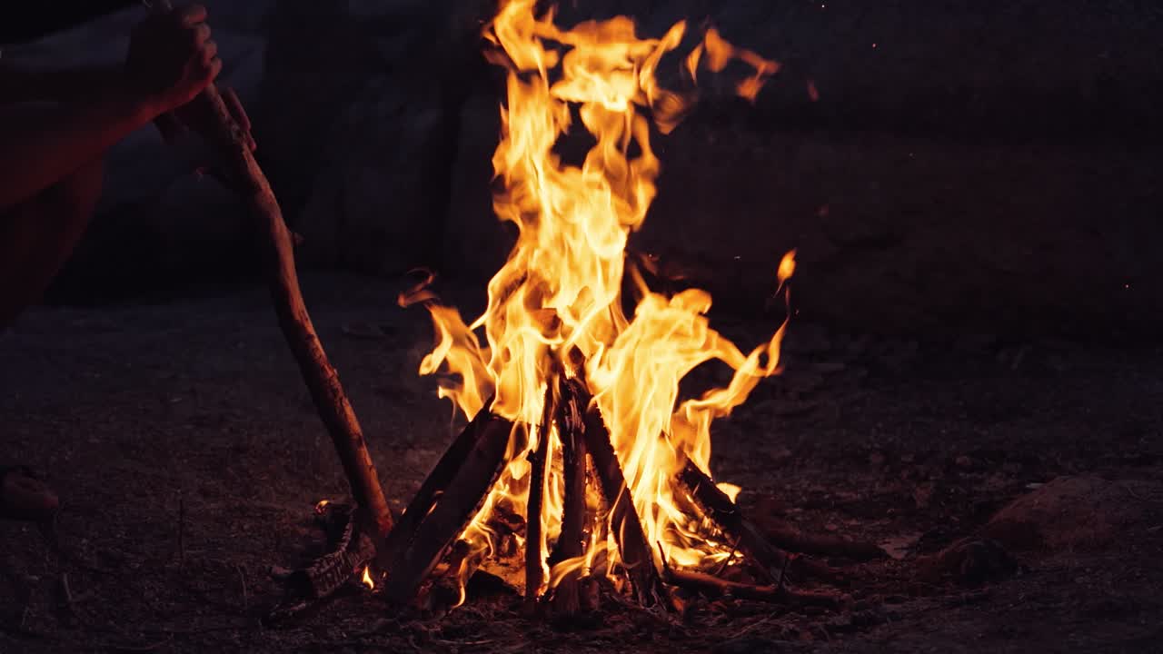A man near the fire in the evening. Burning Wood. Slow motion
