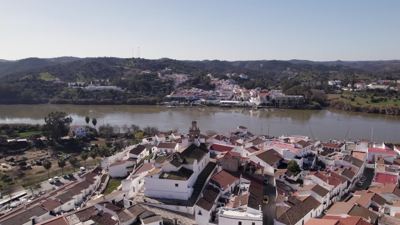 vista aérea de dos pueblos en diferentes países uno frente al otro sobre el río, alcoutim y sanlucar de guadiana
