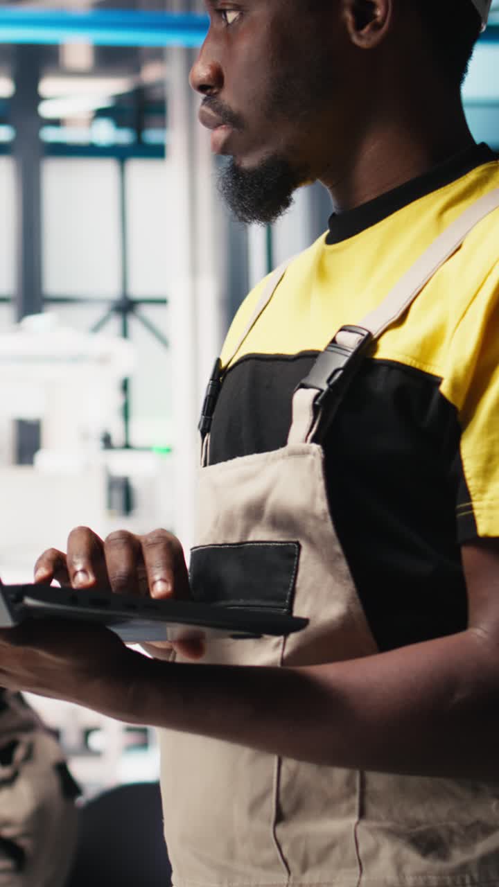 Vertical Video Black engineer in photovoltaics factory diagnoses malfunctioning systems