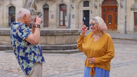 älterer-Tourist,-Großvater,-Der-In-Der-Alten-Sommerstadt-Mit-Einer-Retro-Kamera-Fotos-Von-Seiner-Großmutter-Macht