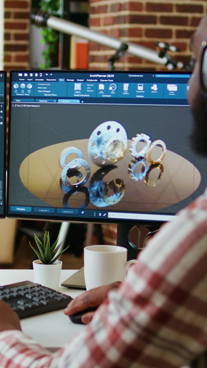 Video verticale. Un designer industriale afroamericano lavora su un software CAD e ascolta musica