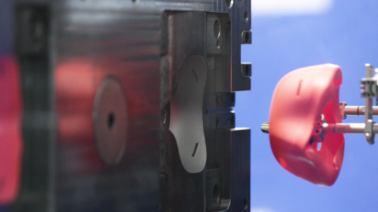 사출 금형에서 로봇 팔에 의해 제거된 성형 플라스틱 제품