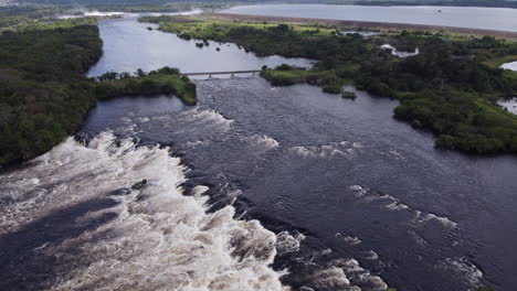aerial view of a river with rapids flowing towards a dam and reservoir