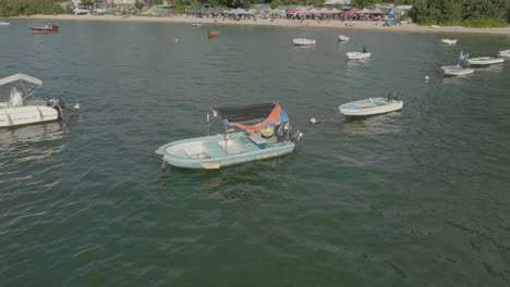 boat-moored-at-bay-in-Hong-Kong-China,-aerial-view-of-small-wooden-boat-foaling-on-water