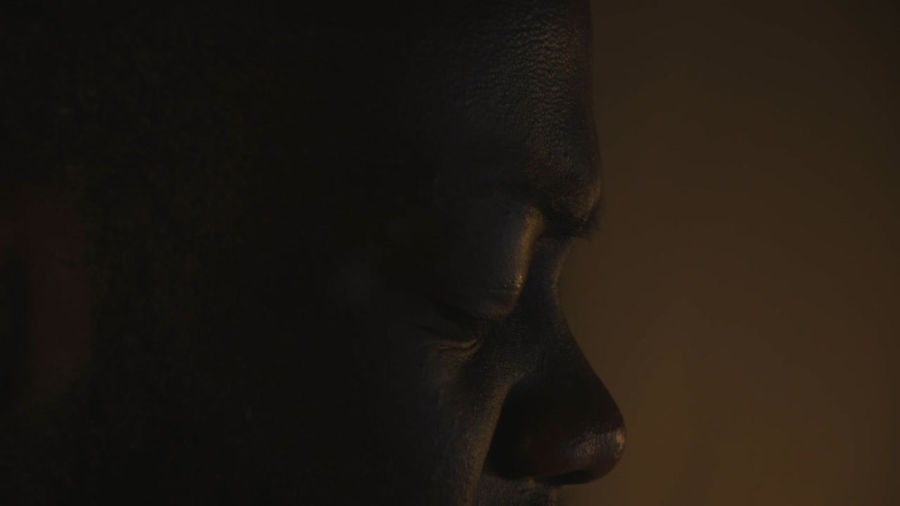 primer plano de un hombre negro escuchando profundamente música mientras está en casa