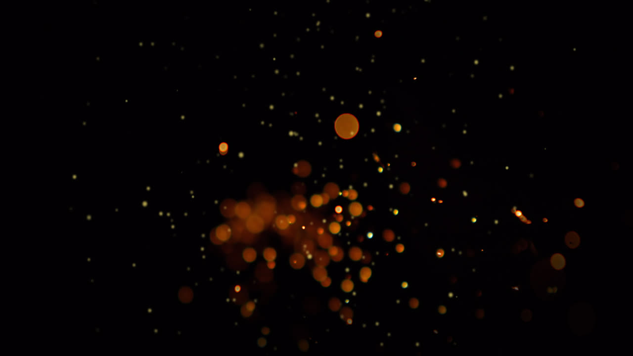 animación de manchas de luz y puntos dorados que caen sobre un fondo negro