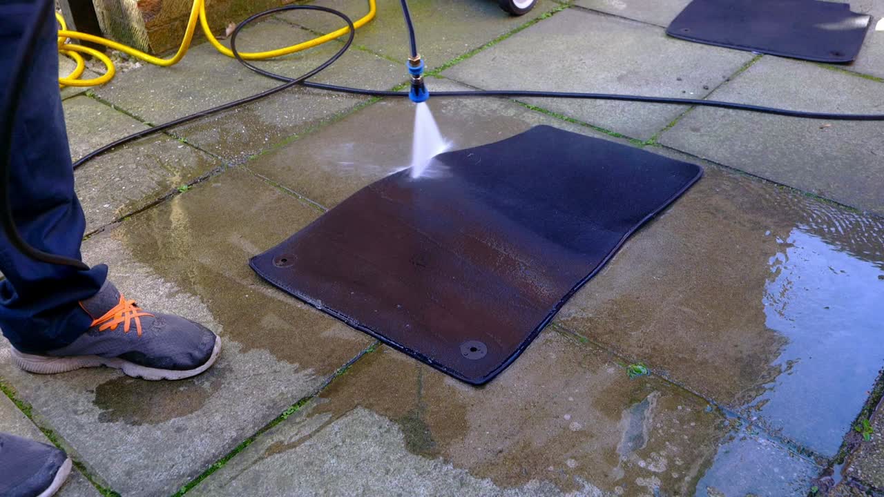 Pressure washing, rinsing, largecar foot with blue nozzle jet wash - wide shot