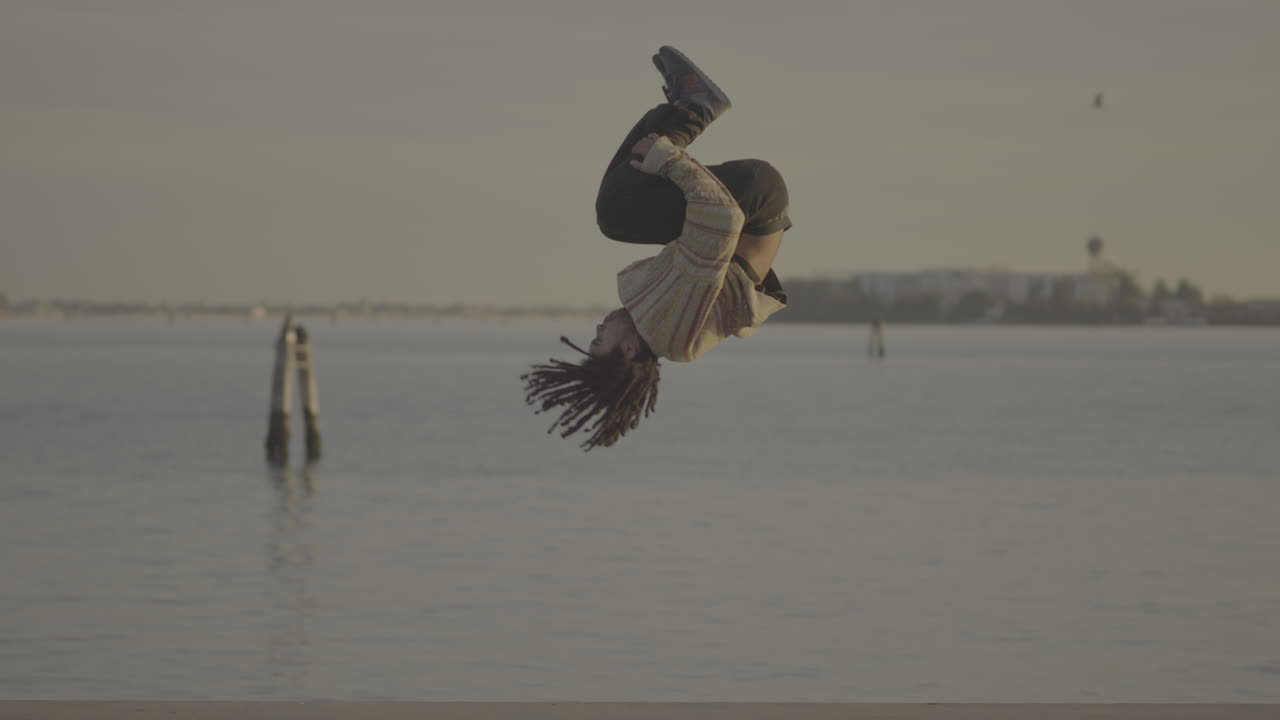 Man Performing Yoga and Parkour Tricks by the Waterfront