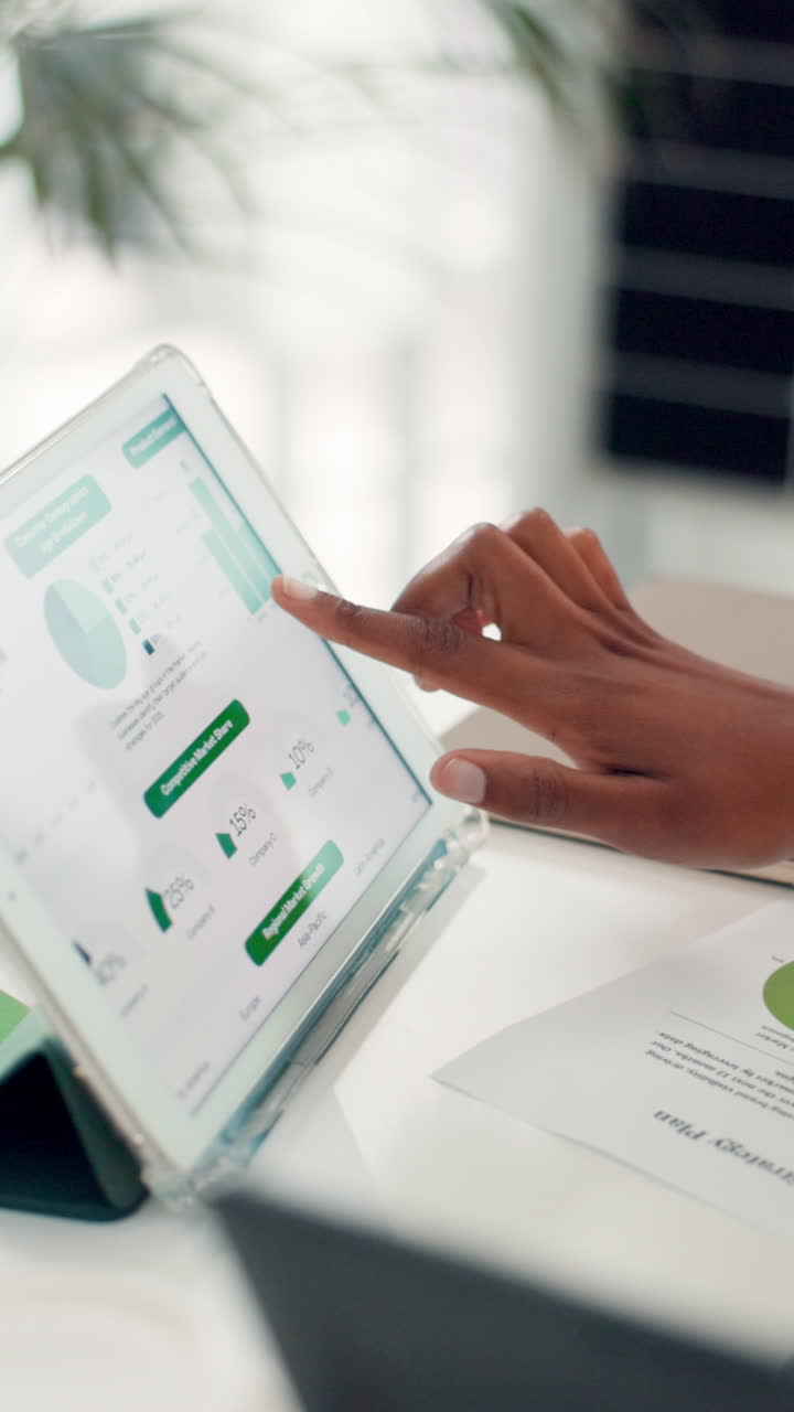 Mano con tablet digitale che mostra dati aziendali e grafici