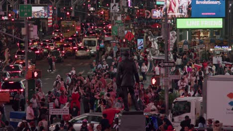 bustling times square filled with people and traffic, surrounded by glowing billboards at dusk