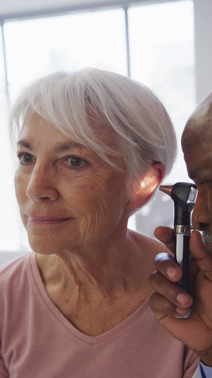 video: un médico afroamericano examina a una anciana caucásica en el hospital