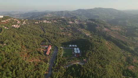 San-Marino,-Italy,-tilt-up-drone-view-on-the-forest