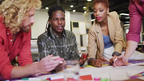 Happy-diverse-business-people-discussing-work-during-meeting-at-office