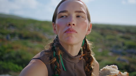 woman tasting delicious bread on green hill closeup. countryside girl smell loaf