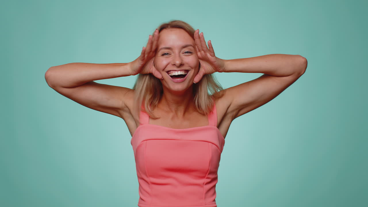 Funny joyful woman making playful silly facial expressions, grimacing, fooling around showing tongue