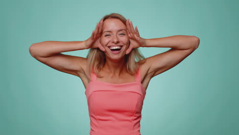 funny joyful woman making playful silly facial expressions, grimacing, fooling around showing tongue