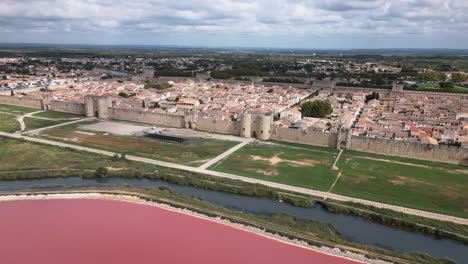 drone shot of an old city in france with pink ocean and a river