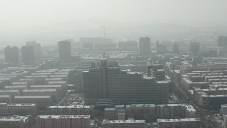 una foto aérea de una ciudad comunista industrial llena de niebla y smog, plagada de contaminación atmosférica.