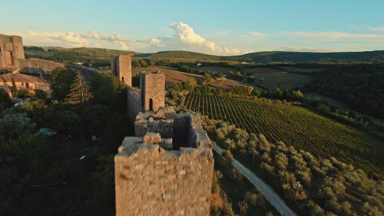 vuelo rápido sobre la comuna de monteriggioni al atardecer, provincia de siena, italia