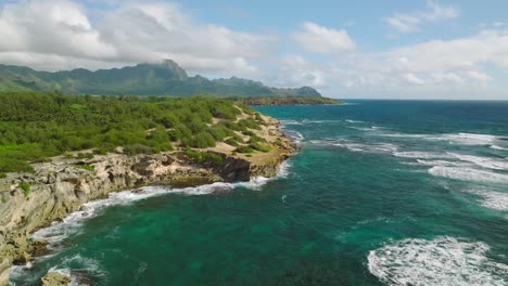 Aerial-shot-tracking-right-over-the-cliff-at-Shipwreck-beach-traveling-towards-the-ocean