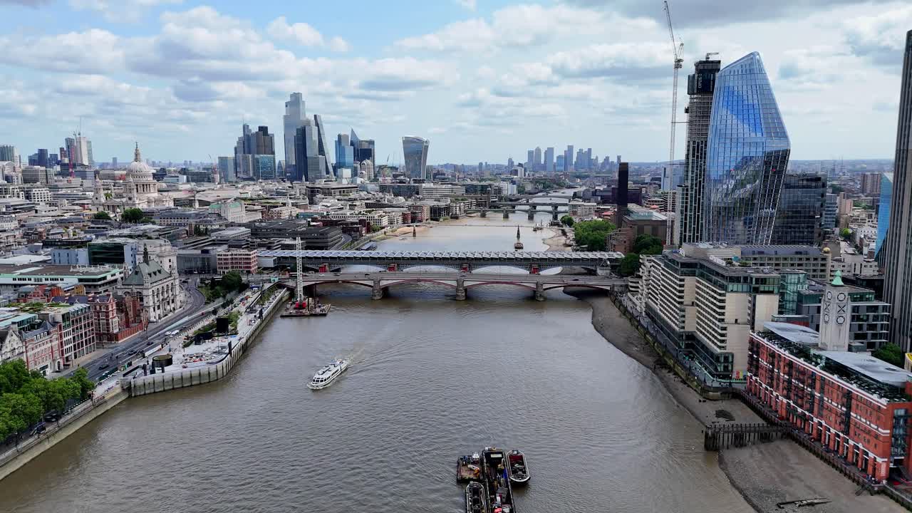 Soaring over the iconic Thames River, this aerial footage captures the journey eastward from the striking OXO Tower towards Blackfriars Bridge and the stunning One Blackfriars skyscraper.