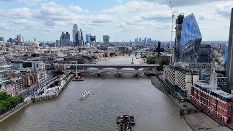 soaring over the iconic thames river, this aerial footage captures the journey eastward from the striking oxo tower towards blackfriars bridge and the stunning one blackfriars skyscraper.
