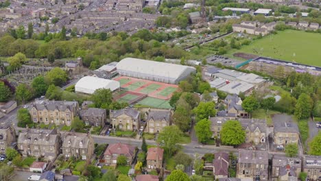 Toma-Aérea-De-Un-Club-De-Tenis-Y-Canchas-En-Una-Urbanización-Inglesa