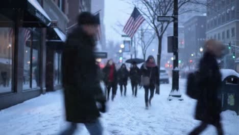 a wintry scene of urban life: people braving the snow and cold as they walk along a busy city street surrounded by snow and flags on a chilly day
