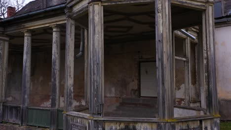 Wooden-porch-of-Burtnieki-Manor,-drone-flying-insdie