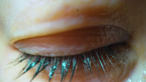 woman with smeared makeup winks by red eye macro view