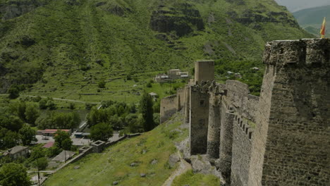 Historic-Khertvisi-Fortress-On-Rocky-Hilltop-With-Green-Mountain-Slopes-In-The-Background