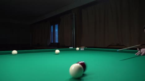 a sports game of billiards, pool or snooker on a billiard table with a green cloth.hitting billiard balls with a cue. cue kick.participate in games and competitions,score a goal in the pocket in match