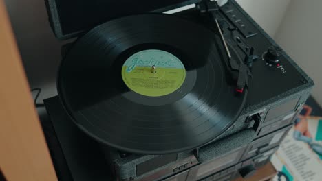 close up of a vinyl record spinning on a turntable stereo player with visible grooves