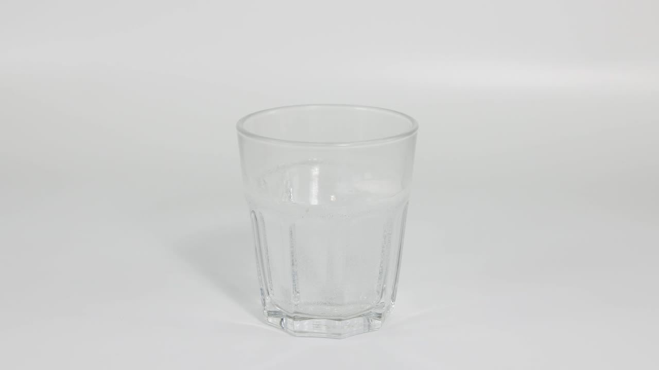 el comprimido se disuelve, creando burbujas en un vaso de agua