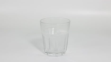 el comprimido se disuelve, creando burbujas en un vaso de agua