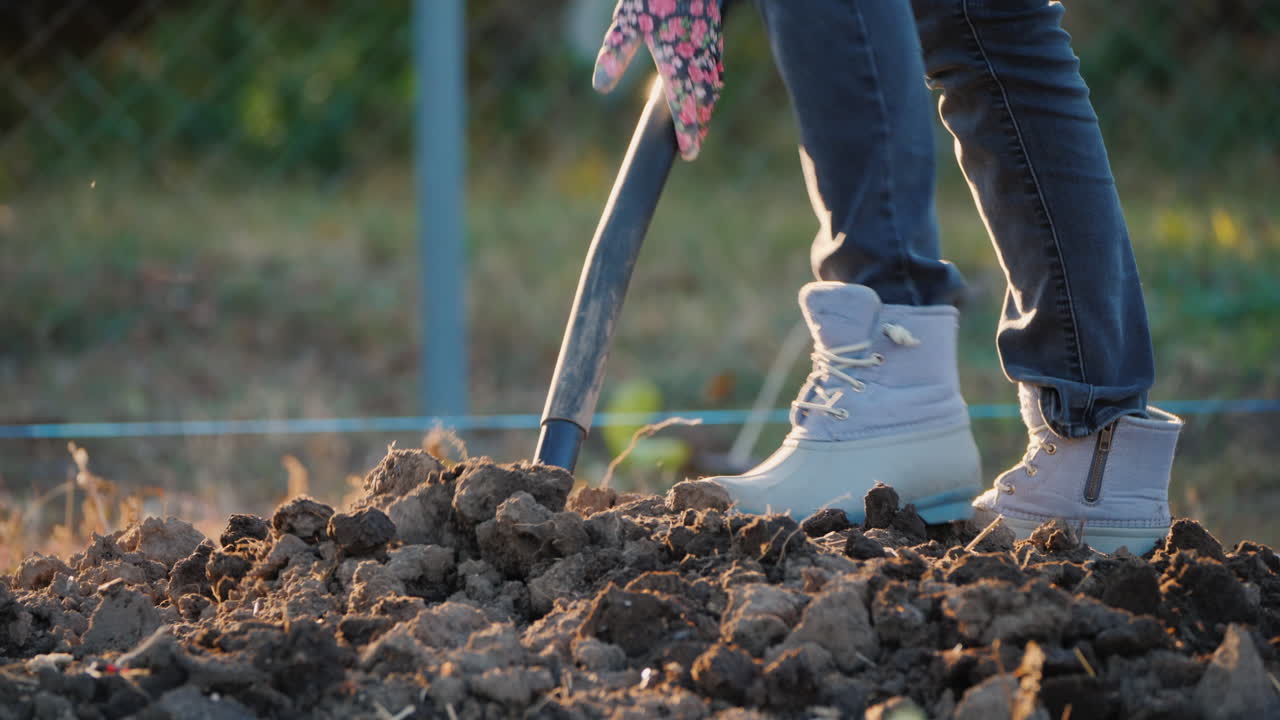 la agricultora cava una huerta en el marco solo se ven las piernas con zapatos de trabajo