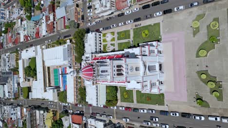 Aerial-top-down-vertical-shot-of-beautiful-Sacred-Heart-of-Jesus-with-city-of-Moca-in-background---Tilt-up-shot