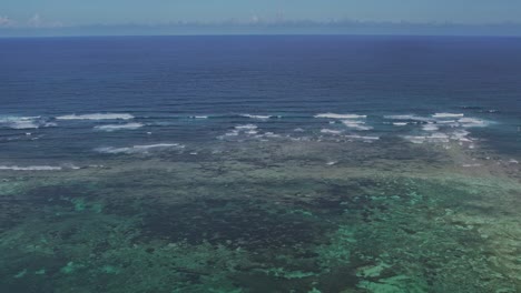 aerial footage of a shallower blue lagoon of corals in the ocean