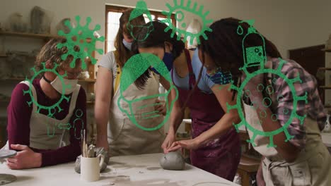 Animation-of-virus-icons-over-diverse-workers-with-face-masks-forming-pottery