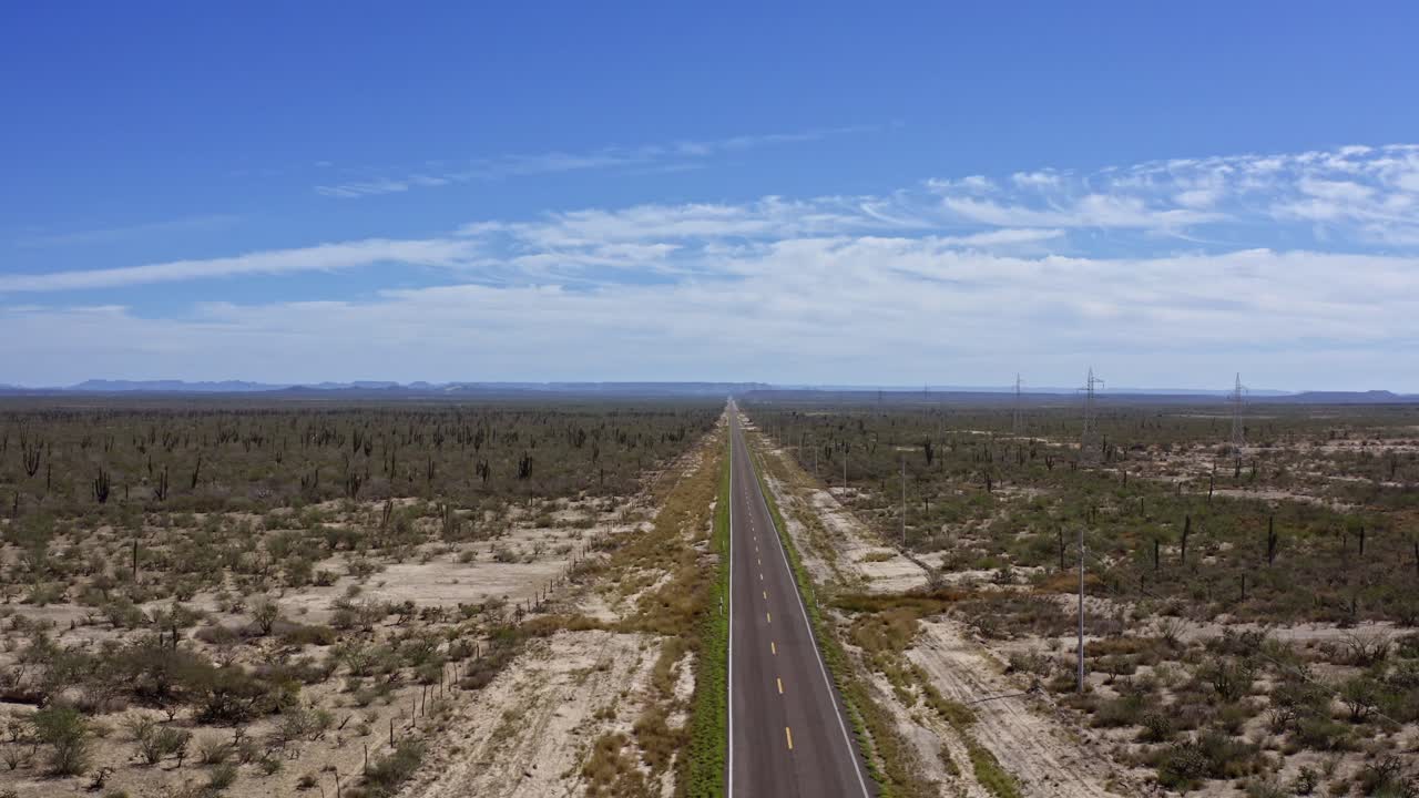 A long highway cuts through the vast, remote landscape of Cabo San Lucas, Mexico