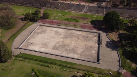 Vista-Aérea-Rotacional-Que-Muestra-A-Los-Patinadores-Rodando-Sobre-La-Superficie-Dura-De-Una-Pista-De-Patinaje-De-Hormigón