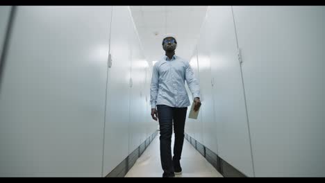engineer walking through server room corridor