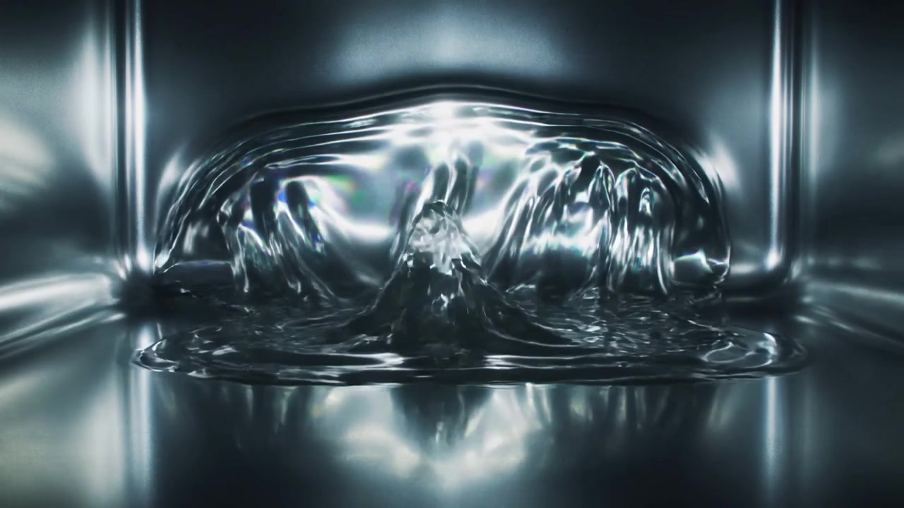 Liquido che si agita in una pozza dopo un impulso centrale, salendo, espandendosi a ventaglio e ricadendo in un serbatoio lucido, riflettendo la luce.
