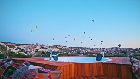 Pool-Auf-Dem-Dach-In-Kappadokien-Und-Bunte-Heißluftballons,-Die-Im-Hintergrund-Fliegen