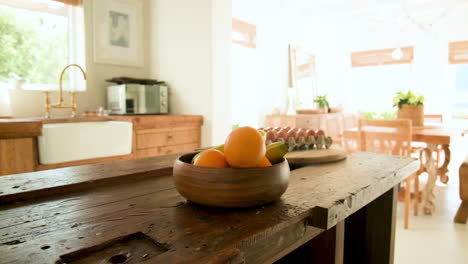 fresh fruit and eggs on rustic kitchen table in bright, cozy home
