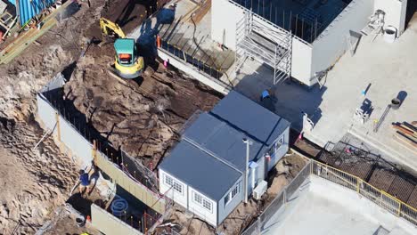 construction site with excavator and portable cabins