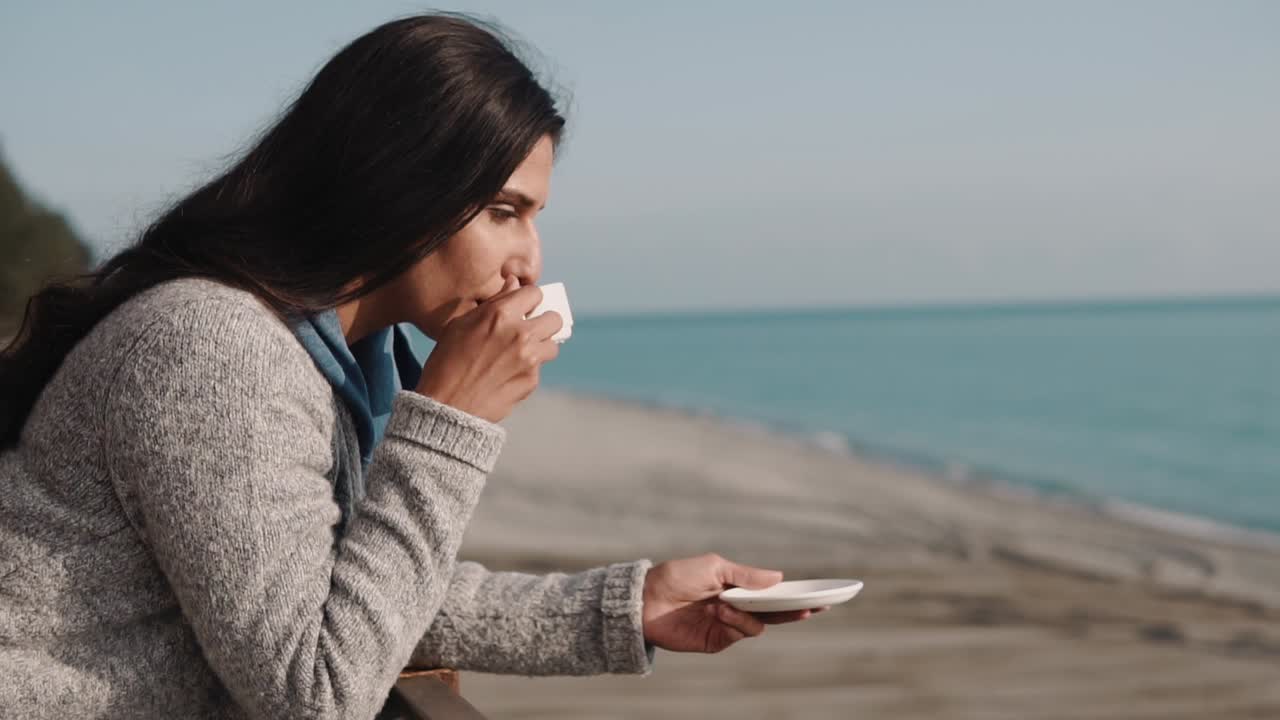 해변에서 커피를 마시는 여자