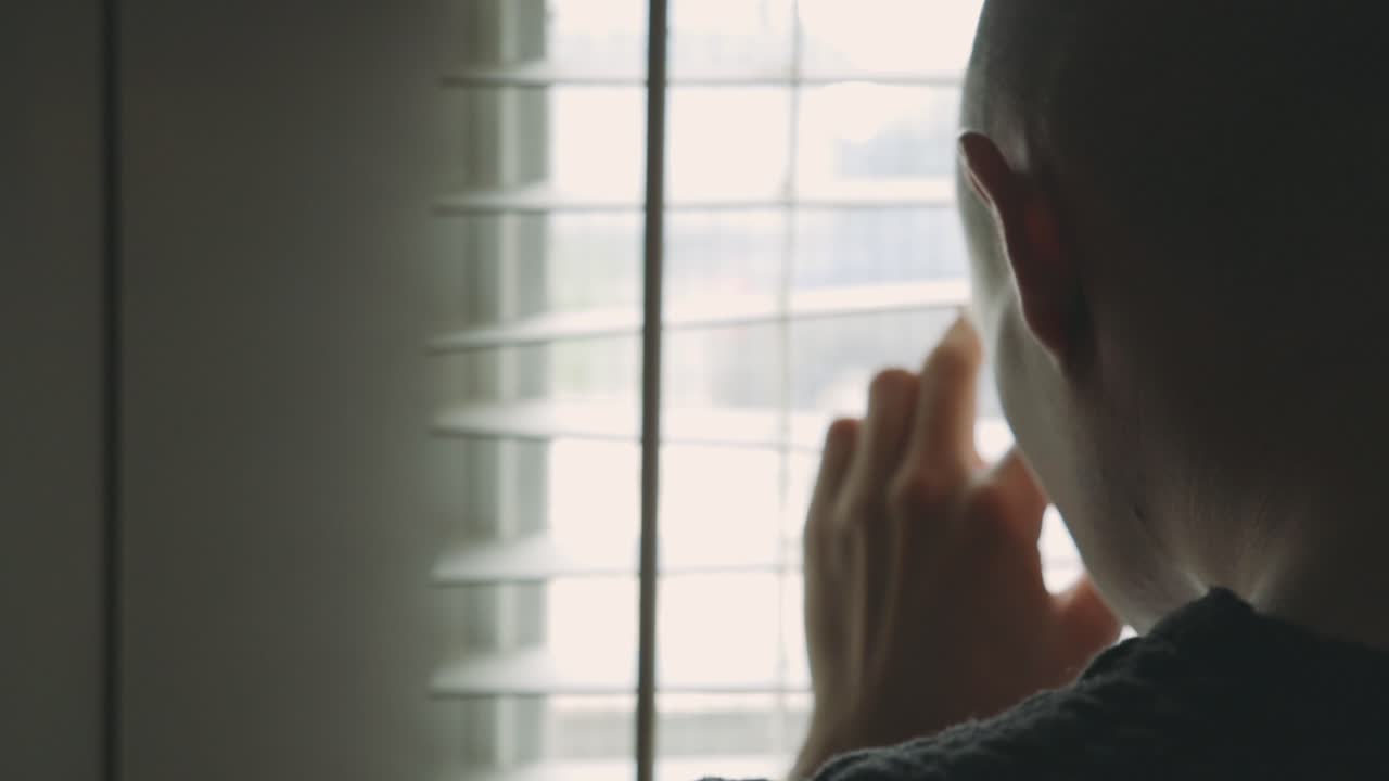 Sad Man Peeping From The Window Blinds Of His Room - Closeup Shot